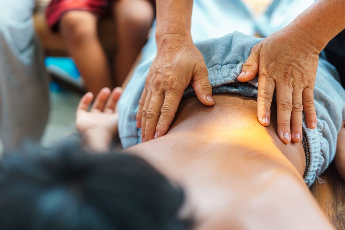 A soothing back massage performed by a therapist outdoors, focusing on relaxation and well-being.