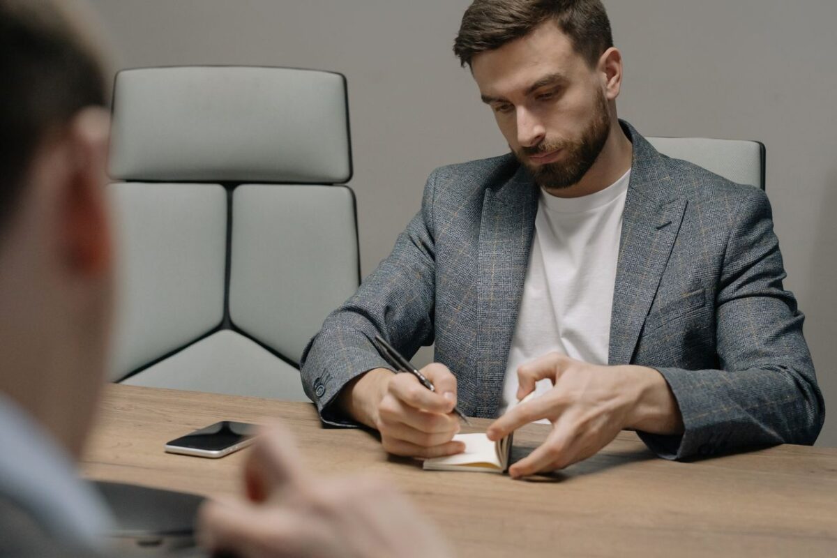 A businessman writing notes during a meeting, showcasing focus and professionalism.